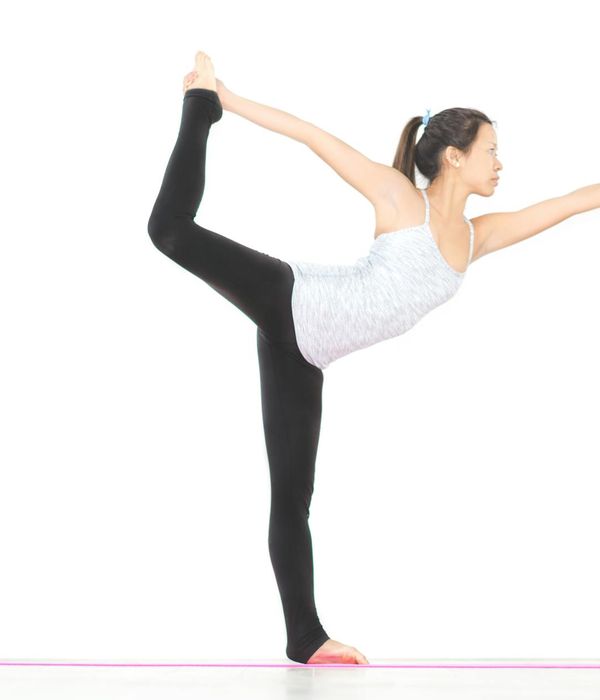 Woman performing a graceful yoga pose, illustrating body harmony and flexibility.